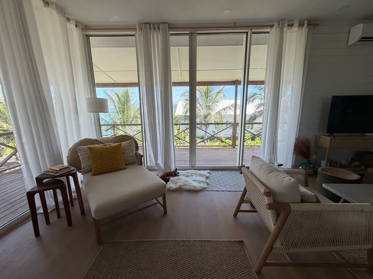 Reading corner by the veranda doors with sea views at Blue Moon Cottage