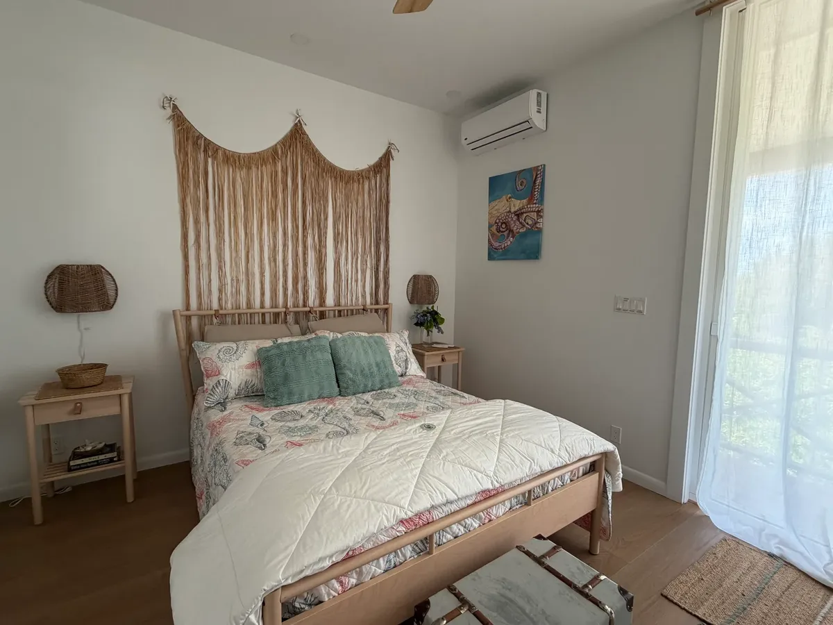 Second queen bedroom with macramé headboard at Blue Moon Cottage